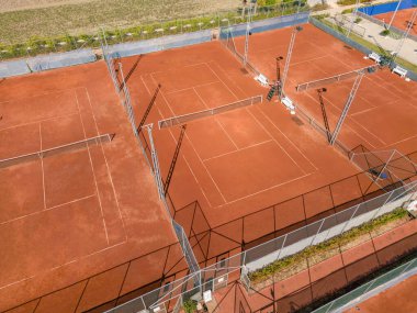 Güneşli bir günde boş kil tenis kortunun havadan görünüşü