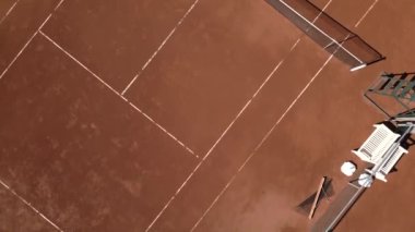 Güneşli bir günde boş kil tenis kortunun havadan görünüşü