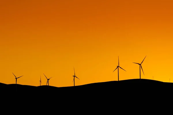 日落时站在山上的多台风力涡轮机发电 — 图库照片