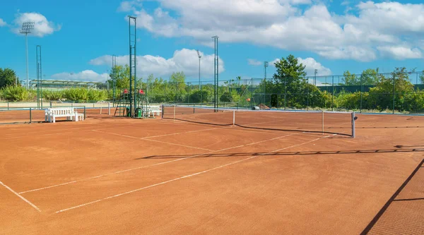 晴れた日に空の粘土テニスコートのベースラインとネット — ストック写真