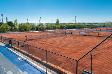 Güneşli bir günde boş kil tenis kortunun havadan görünüşü