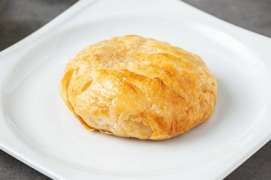 İzmir boyoz beyaz bir porselen tabakta taş bir masada