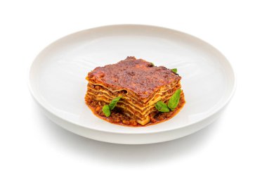 Beyaz arka planda Behamel sosu ve kıymalı et lazanyası