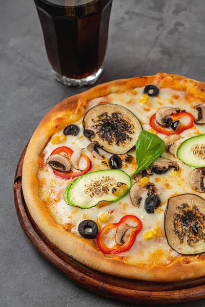 Vegetarian pizza with eggplant, zucchini and mushrooms on dark stone table
