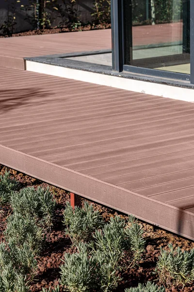 Brown composite deck mounted on the porch of the house