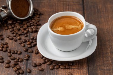Fresh double espresso coffee and coffee beans on wooden table