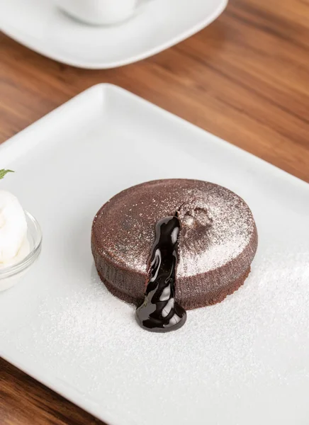 Chocolate souffle with flowing chocolate on a white porcelain plate
