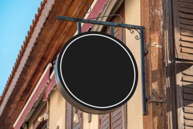 Blank signboard mockup hanging on the wall of the store in the street