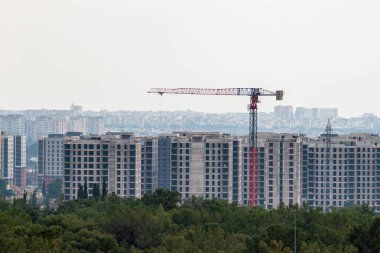Large construction crane working for public housing construction on a cloudy day