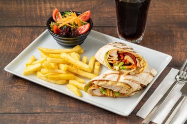 Patates kızartması ve salatalı sebzeli tavuk dürümü.