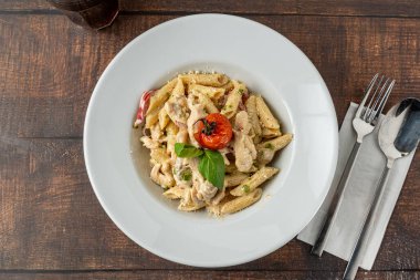 Penne arrabiata pasta with chicken on a white porcelain plate