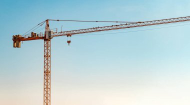 Construction crane in front of cloudless sunny blue sky