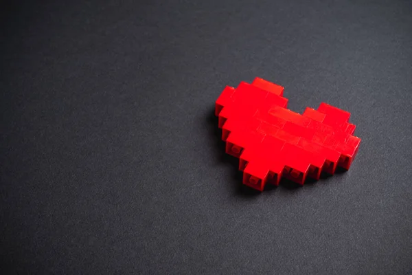 Corazón Rojo Hecho Ladrillos Plástico Sobre Fondo Gris Oscuro — Foto de Stock
