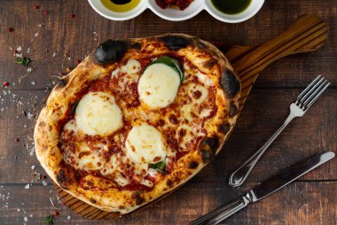 Italian pizza with four cheeses and lots of mozzarella on a cutting board