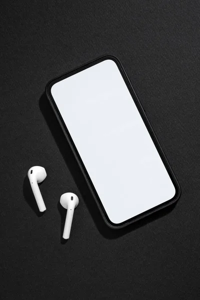 Smartphone Con Pantalla Blanco Auriculares Inalámbricos Lado Sobre Fondo Gris —  Fotos de Stock