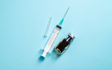 Mavi zemin üzerinde boş kopya alanı olan şeffaf plastik şırınga