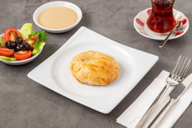 İzmir boyoz beyaz bir porselen tabakta taş bir masada