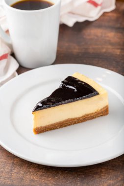 Tahta masada kahve demleyen çikolatalı cheesecake.
