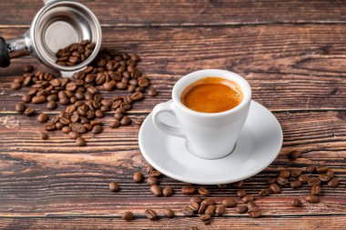 Taze duble espresso kahve, ahşap masada kahve çekirdekleri ile süslenmiş.