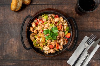 Sauteed chicken with pepper in a cast iron pan
