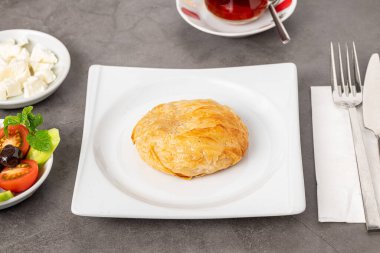 İzmir boyoz beyaz bir porselen tabakta taş bir masada