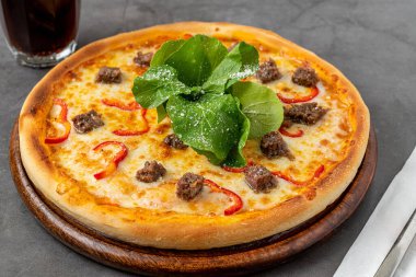 Kırmızı biberli pizza ve taştan masanın üzerinde biftek.