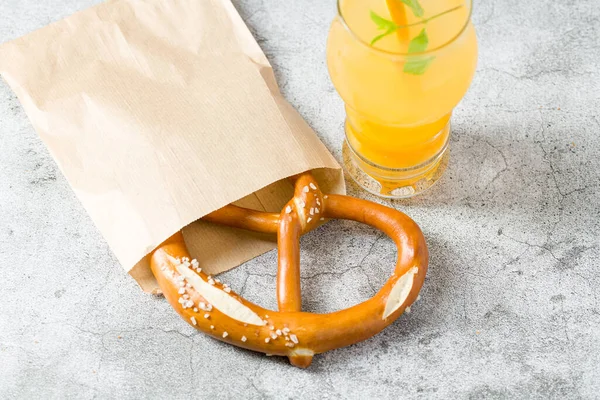 Pretzel Dibungkus Dalam Kertas Pembungkus Dengan Minuman Sampingnya Atas Meja — Stok Foto