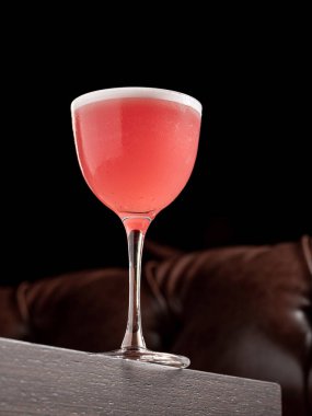 Ahşap masada koyu bir arka planda lüks bir kokteyl.