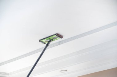 Usta boyanmak üzere odanın tavanına sıva yapıştırıyor.