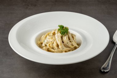 Freshly made fettucini alfredo on a white porcelain plate