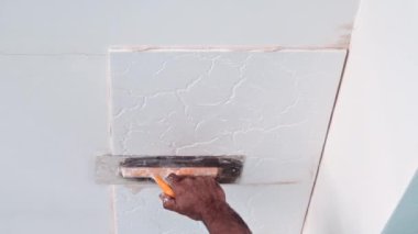 Bir ev mutfağının köpük tavan kiremitlerinin yapıştırıcı sıva uygulaması
