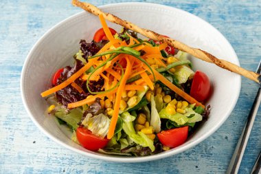 Tahta masadaki beyaz kasede sağlıklı karışık salata. Akdeniz salatası