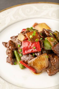 Kırmızı biber, yeşil biber ve soğanla sotelenmiş sıcak ve ekşi et. Asya mutfağı