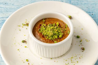 Fıstıklı sufle ve tahini beyaz bir porselen tabakta.