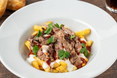 Turkish food cokertme Kebab. Kebab made with thinly sliced beef steak on french fries and yoghurt