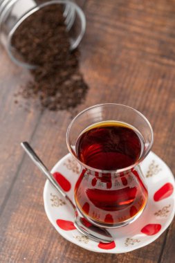 Freshly brewed turkish tea in thin-waisted glass cup on wooden table