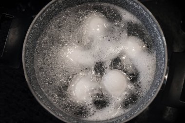 Tavuk yumurtaları pişirme makinesinde çelik bir tencerede kaynatılır. Haşlanmış yumurta.