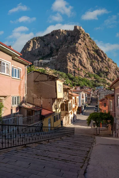 Afyonkarahisar Türkiye 'de geleneksel Türk evleri. Kayalıklardaki Afyon Kalesi ve önündeki Mevlevihane Müzesi