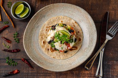 Tahta masadaki porselen tabakta balık ceviche tostu. İspanyol adı tostada ceviche de pescado