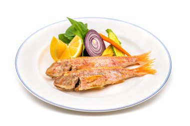 Limon, yeşillik ve soğan gibi garnitürlü leziz ızgara kırmızı kefal balığı.