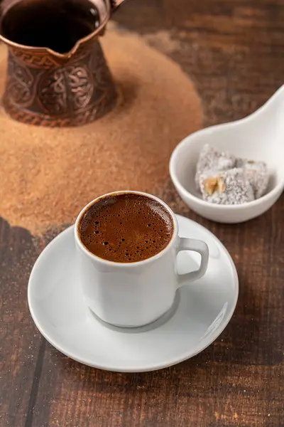 Turkish coffee cooked in hot sand with Turkish delight in a classic coffee cup