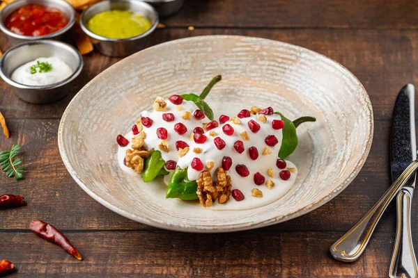 stock image Chiles en Nogada, a traditional Mexican dish made with pablano chili stuffed with meat and fruit and garnished with pomegranate seeds and walnuts