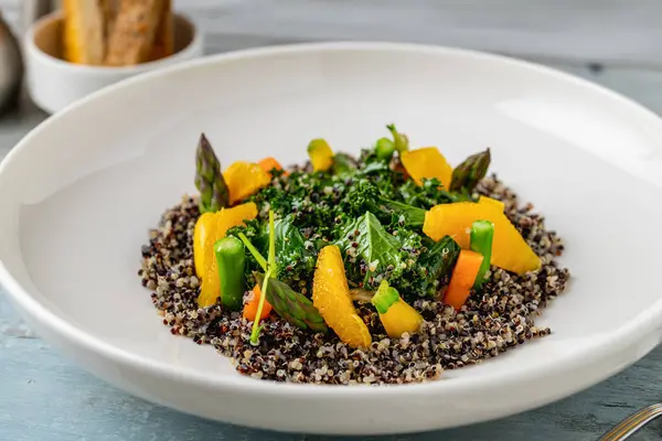 Quinoa Salad Orange Kale Leaves White Porcelain Plate Wooden Table — Stock Photo, Image