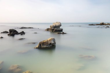 Uzun pozlama tekniğiyle denizdeki kayaların minimalist sanat görüntüsü