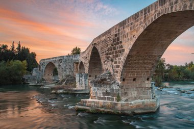 Antalya Türkiye 'de gün doğumunda Koprucay üzerindeki tarihi Aspendos Köprüsü