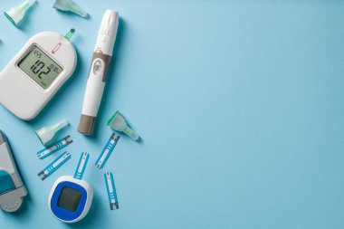 Üst görünüm glukometre, tükenmez kalem ve mavi arka plan şeritleri. Diyabet test kiti