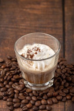 Sıcak espresso con panna cam bardakta ahşap masada