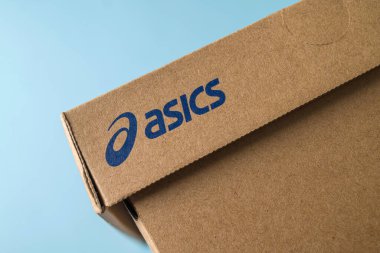 Antalya, Türkiye - 28 Kasım 2023: Asics logosunun basıldığı spor ayakkabı kutusu. mavi arkaplan