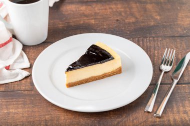 Tahta masada kahve demleyen çikolatalı cheesecake.