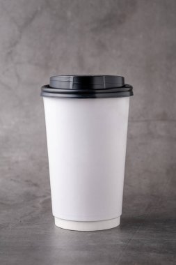 Gri arka planda siyah plastik kapaklı beyaz paket kağıdı.